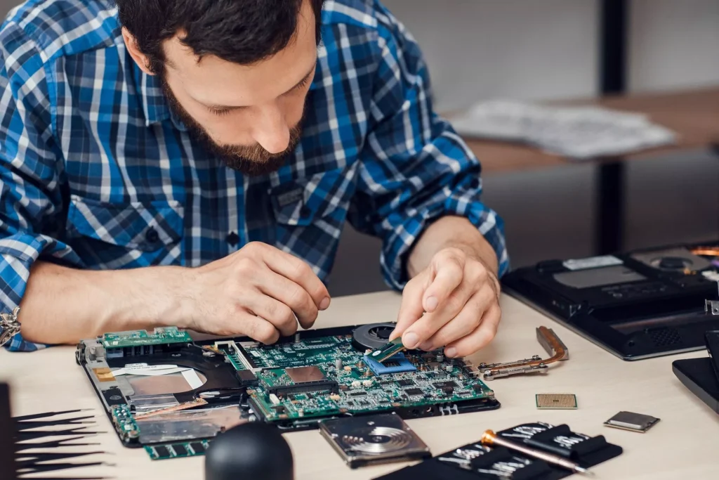 A male hardware engineer repairing a board